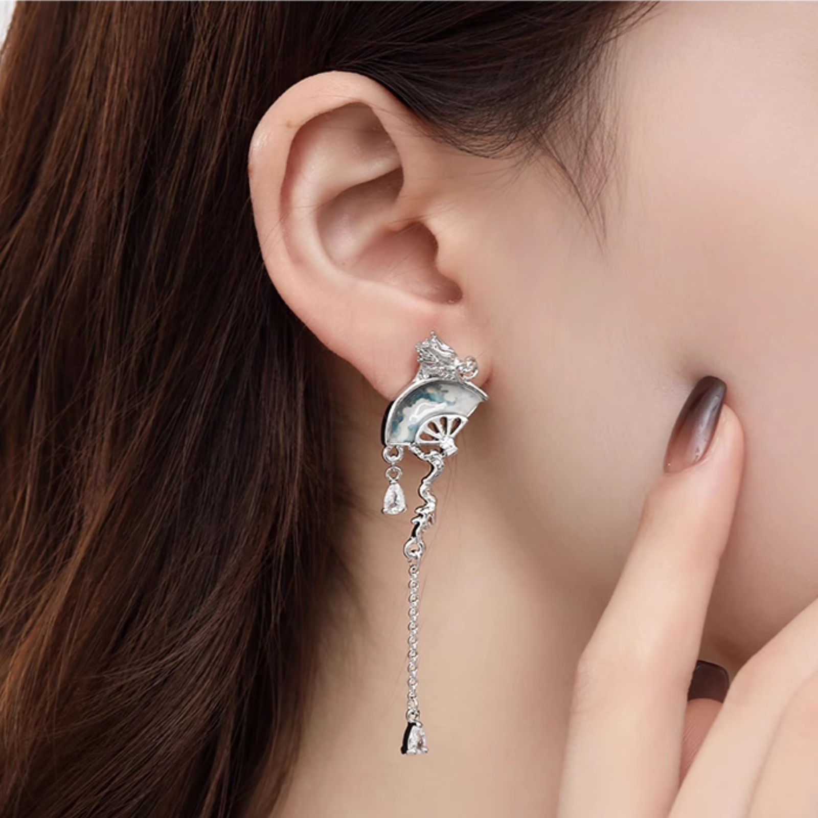 Woman wearing dragon fan tassel earrings
