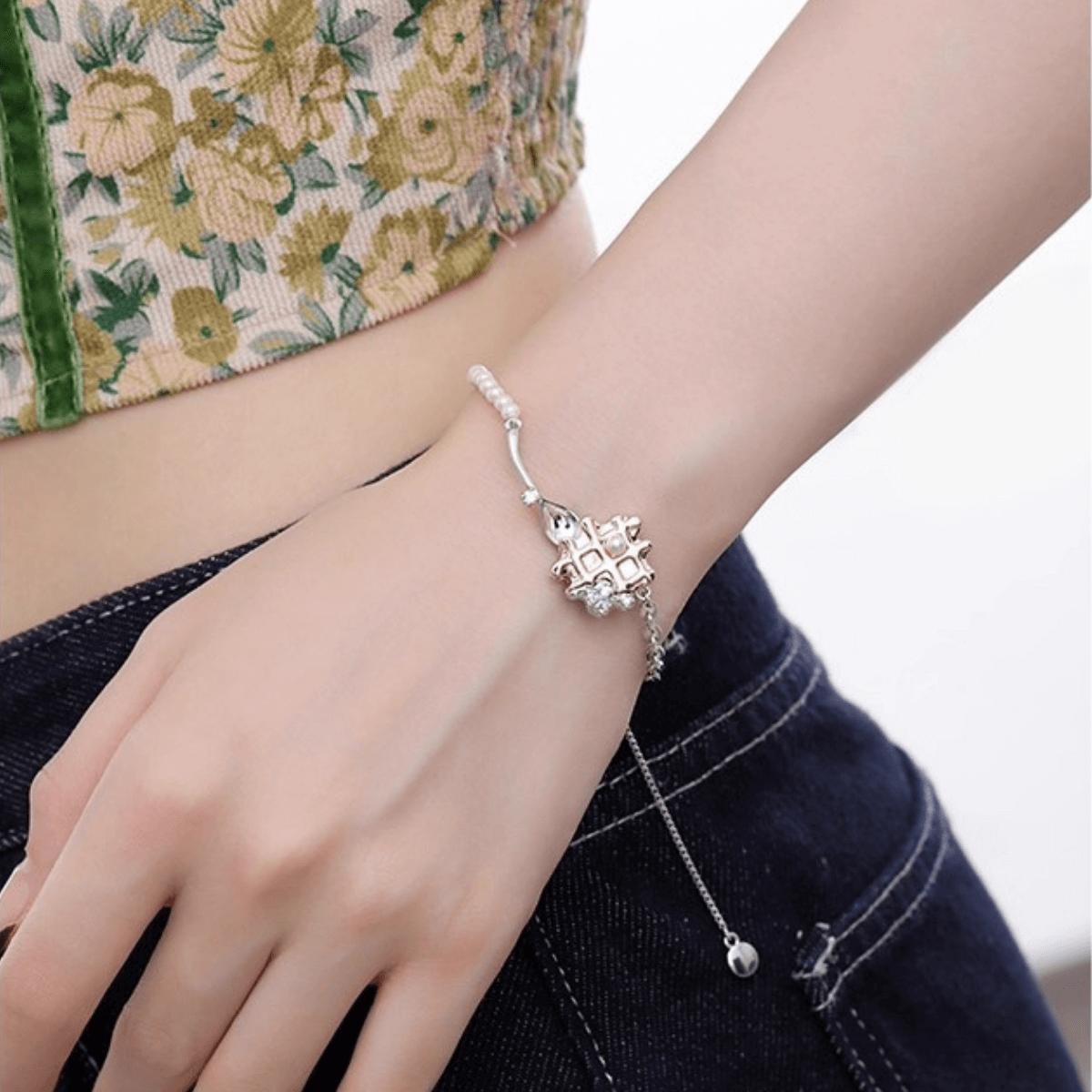 Close-up of a woman's wrist wearing the elegant Enola & SHE Waffle Pearl Bracelet with an adjustable chain.